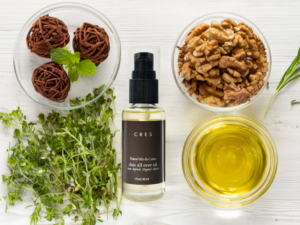 CRES Joie All Over Oil bottle with clean, minimalist packaging, surrounded by natural botanical ingredients like shea butter and jojoba.